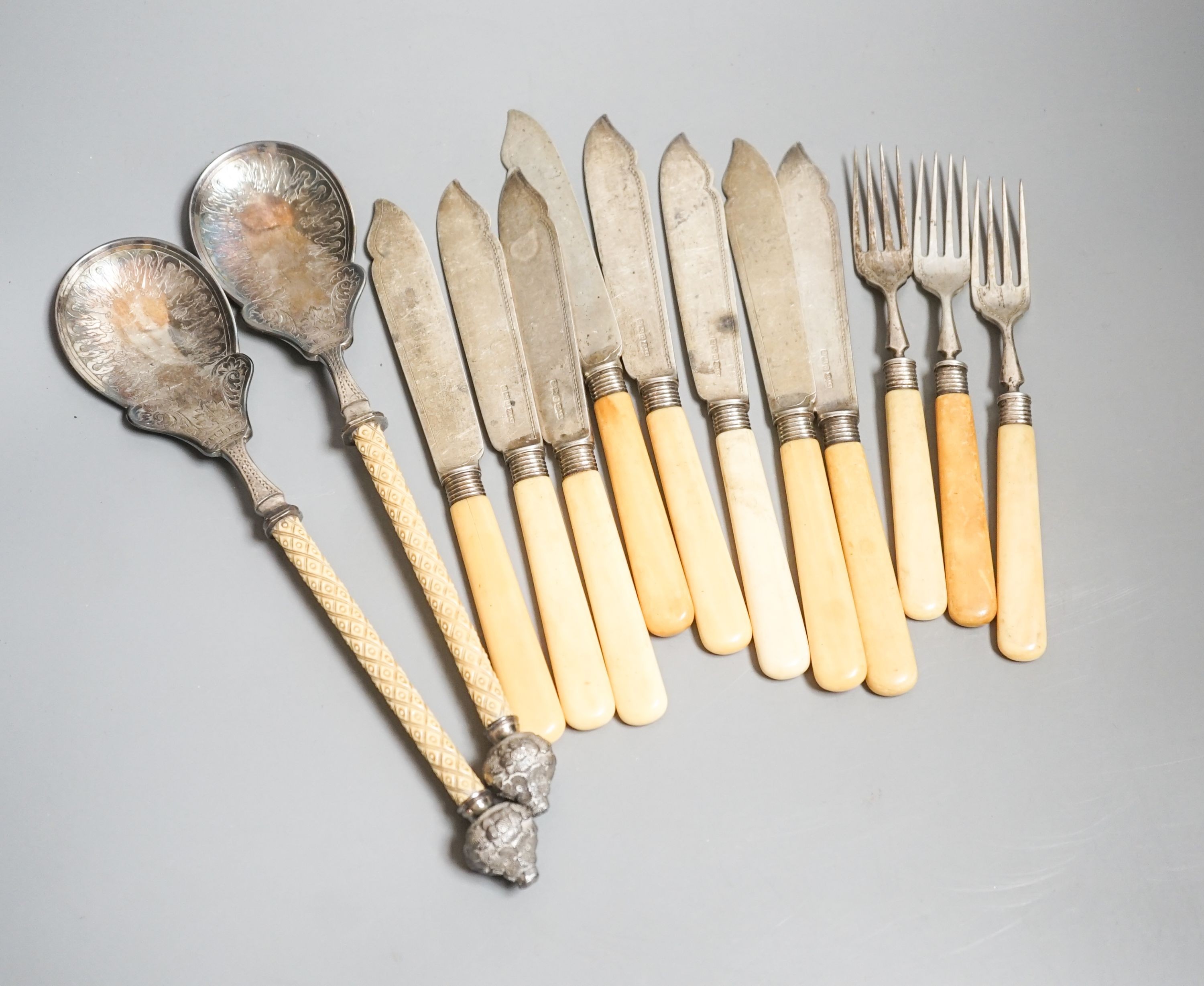 Eight ivory handled silver fish knives and three forks and a pair of plated servers.